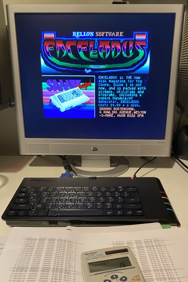 Enceladus disk magazine advert shown on a flatscreen VGA monitor being driven by a ZX Spectrum Next. In front of the computer is a colour table print-out and a scientific calculator.